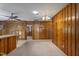 Spacious living room features knotty pine walls, neutral carpet, and a view into another room at 5517 Spring Rd, Raleigh, NC 27603