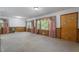 Spacious, airy living room featuring large windows with floral curtains and comfortable seating at 5517 Spring Rd, Raleigh, NC 27603