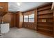 Living space with wood paneling, built-in shelves, closet and a window offering natural light at 5517 Spring Rd, Raleigh, NC 27603