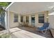 Covered patio with seating, a wooden floor, and a glass door leading into the house at 5517 Spring Rd, Raleigh, NC 27603
