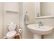 Cozy powder room featuring a pedestal sink and a toilet, illuminated by soft natural light at 5622 Osprey Cove Dr, Raleigh, NC 27604