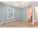 Bedroom with a large window, light blue walls, ceiling fan, and an ensuite bathroom at 5622 Osprey Cove Dr, Raleigh, NC 27604