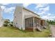 A view of the back exterior of a home, including a screened-in porch and grassy yard at 5622 Osprey Cove Dr, Raleigh, NC 27604