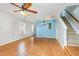Bright living room featuring hardwood floors, a ceiling fan, and stairway to the upper floor at 5622 Osprey Cove Dr, Raleigh, NC 27604