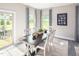 Well-lit dining area with a dark wood table, white chairs, and stylish patterned curtains at 568 Impala, Wendell, NC 27591