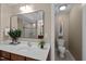 Bathroom with a large mirror over the vanity and a view into the shower area with tile surround at 606 Churton Grove Blvd, Hillsborough, NC 27278
