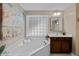Bright bathroom features a soaking tub beneath a window with privacy glass and neutral colors at 606 Churton Grove Blvd, Hillsborough, NC 27278