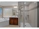 Luxurious bathroom with a large soaking tub, shower with glass door, a window with a backyard view and tile flooring at 606 Churton Grove Blvd, Hillsborough, NC 27278