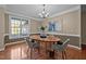 Formal dining room featuring dark wood floors, elegant lighting, and a large window at 606 Churton Grove Blvd, Hillsborough, NC 27278