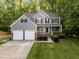 Two-story home featuring gray siding, black shutters, two-car garage, and a lush green lawn at 606 Churton Grove Blvd, Hillsborough, NC 27278