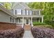 A charming front porch with brick accents and manicured landscaping welcomes you home at 606 Churton Grove Blvd, Hillsborough, NC 27278