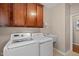 Efficient laundry room with front load washer and dryer and a utility sink for added convenience at 606 Churton Grove Blvd, Hillsborough, NC 27278