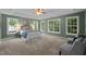 Spacious main bedroom featuring a tray ceiling, ceiling fan, three windows, and carpet flooring at 606 Churton Grove Blvd, Hillsborough, NC 27278