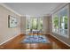 Well-lit home office featuring hardwood floors, an accent rug and bright windows with a wooded view at 606 Churton Grove Blvd, Hillsborough, NC 27278