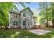 Charming gray two-story home with a wooden deck and patio area surrounded by lush greenery at 606 Churton Grove Blvd, Hillsborough, NC 27278