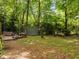 Spacious backyard featuring a lush lawn, mature trees, and a relaxing deck with bench seating at 61 Stone Ledge, Pittsboro, NC 27312