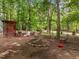 Backyard featuring a fire pit and seating area surrounded by trees at 61 Stone Ledge, Pittsboro, NC 27312