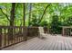 Spacious wooden deck with a chair surrounded by lush trees at 61 Stone Ledge, Pittsboro, NC 27312