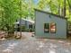 Exterior of the home and detached structure with a gravel yard and surrounding trees at 61 Stone Ledge, Pittsboro, NC 27312