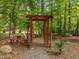 Landscaped backyard with a decorative pergola and stone pathway at 61 Stone Ledge, Pittsboro, NC 27312