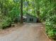Charming home exterior nestled among mature trees and a gravel driveway at 61 Stone Ledge, Pittsboro, NC 27312