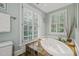 Bathroom featuring a large soaking tub with shutters and tile flooring at 612 Swift Ave, Durham, NC 27701