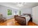Sunlit bedroom featuring hardwood floors, a cozy rocking chair, and windows with picturesque outdoor views at 612 Swift Ave, Durham, NC 27701