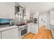 Updated kitchen with stainless steel appliances, white cabinets, gray tile backsplash, and hardwood flooring at 612 Swift Ave, Durham, NC 27701