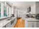 Modern kitchen featuring stainless steel appliances, grey subway tile backsplash, and hardwood flooring at 612 Swift Ave, Durham, NC 27701
