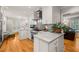 Bright kitchen featuring white cabinetry, stainless appliances, gray backsplash, and hardwood floors at 612 Swift Ave, Durham, NC 27701