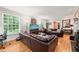 Bright living room with hardwood floors, large windows, and leather sectional at 612 Swift Ave, Durham, NC 27701