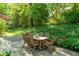 Charming outdoor patio features a wooden table and chairs surrounded by lush greenery at 612 Swift Ave, Durham, NC 27701