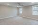 Spacious bedroom with plush carpet, neutral walls, two windows, and modern ceiling fan at 66 Sanders Farm Dr, Smithfield, NC 27577