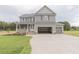 Charming two-story home featuring a covered porch, attached garage, and a well-manicured lawn at 66 Sanders Farm Dr, Smithfield, NC 27577