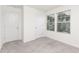 A bright bedroom features neutral carpet and two windows dressed with horizontal blinds at 69 Curling Creek Dr # I286, Clayton, NC 27527