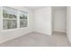 A bright bedroom features neutral carpet and two windows dressed with horizontal blinds at 69 Curling Creek Dr # I286, Clayton, NC 27527