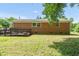 Home backyard with a brick facade and a wooden ramp, surrounded by well-maintained greenery at 714 W Mckinley St, Mebane, NC 27302