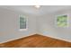 Bright bedroom with hardwood floors, two windows, and white walls at 714 W Mckinley St, Mebane, NC 27302