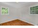 Bedroom is bright with hardwood floors, neutral walls, and two windows with natural light at 714 W Mckinley St, Mebane, NC 27302