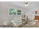 Modern dining area features glass table, neutral chairs, updated ceiling fan, and natural light; virtually staged at 714 W Mckinley St, Mebane, NC 27302