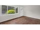 Bedroom with polished hardwood floors and a large window overlooking the yard at 714 W Mckinley St, Mebane, NC 27302