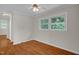 Empty room with hardwood floors and a large window offering natural light at 714 W Mckinley St, Mebane, NC 27302