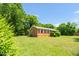 View of a well-maintained brick home with a lush green yard and mature trees at 714 W Mckinley St, Mebane, NC 27302