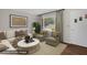 Bright living room featuring a large window, neutral furniture, and stylish decor; virtually staged at 714 W Mckinley St, Mebane, NC 27302