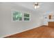 Sunlit living room with hardwood floors, two windows, and white walls at 714 W Mckinley St, Mebane, NC 27302