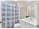 White vanity bathroom with mirror, toilet, and a blue patterned shower curtain at 750 James Norris Rd, Angier, NC 27501