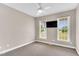 Neutral bedroom features carpet, a ceiling fan, natural light from two windows, and a wall-mounted television at 750 James Norris Rd, Angier, NC 27501