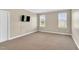 Neutral bedroom featuring carpet, a wall mounted television, and natural light from two windows at 750 James Norris Rd, Angier, NC 27501