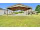 Covered carport featuring exposed wooden beams, lighting, a concrete floor, and space for parking and outdoor activities at 750 James Norris Rd, Angier, NC 27501