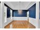 Elegant dining room featuring dark blue walls, hardwood floors, and a tray ceiling at 750 James Norris Rd, Angier, NC 27501